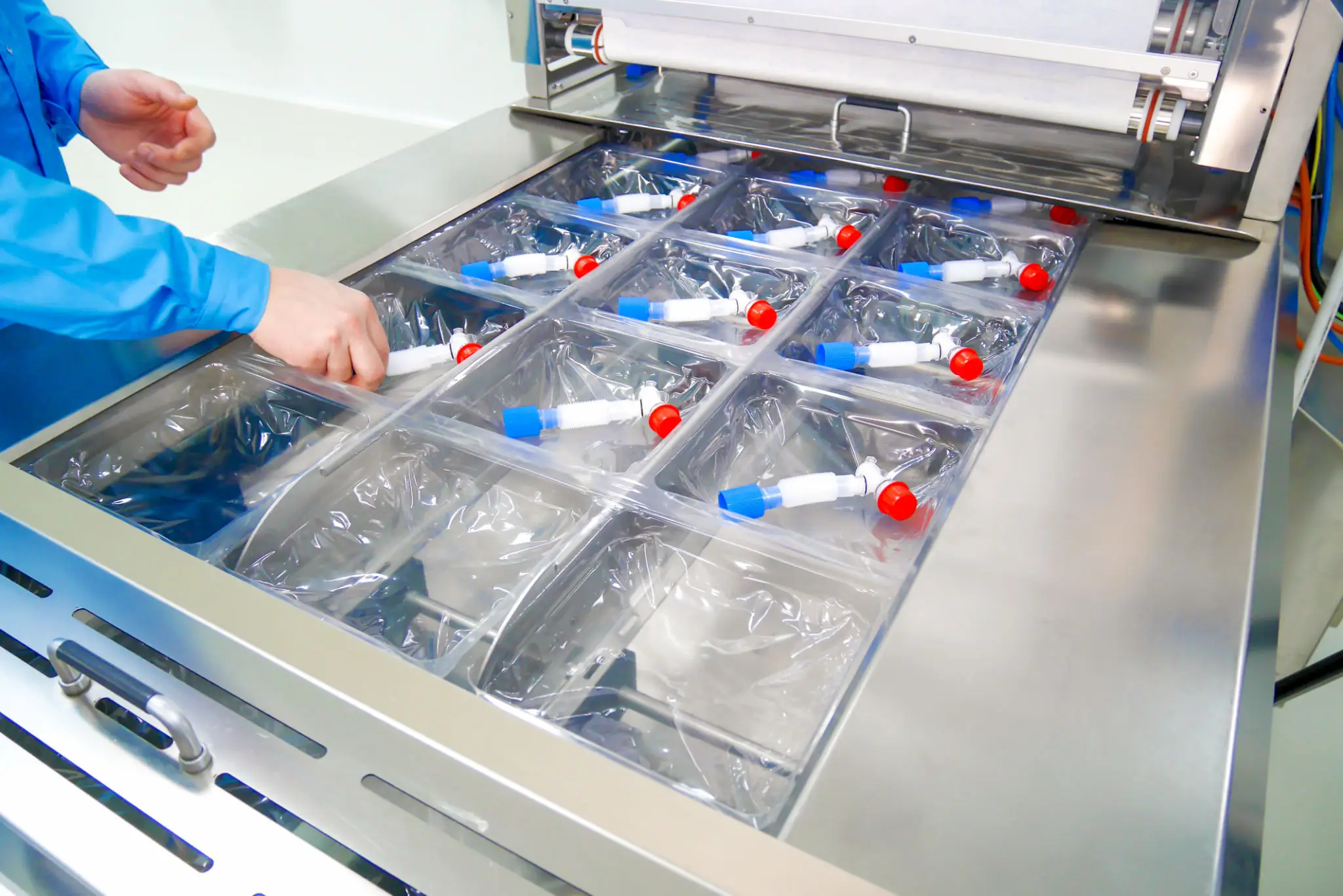Technician arranging medical spout fittings in tray
