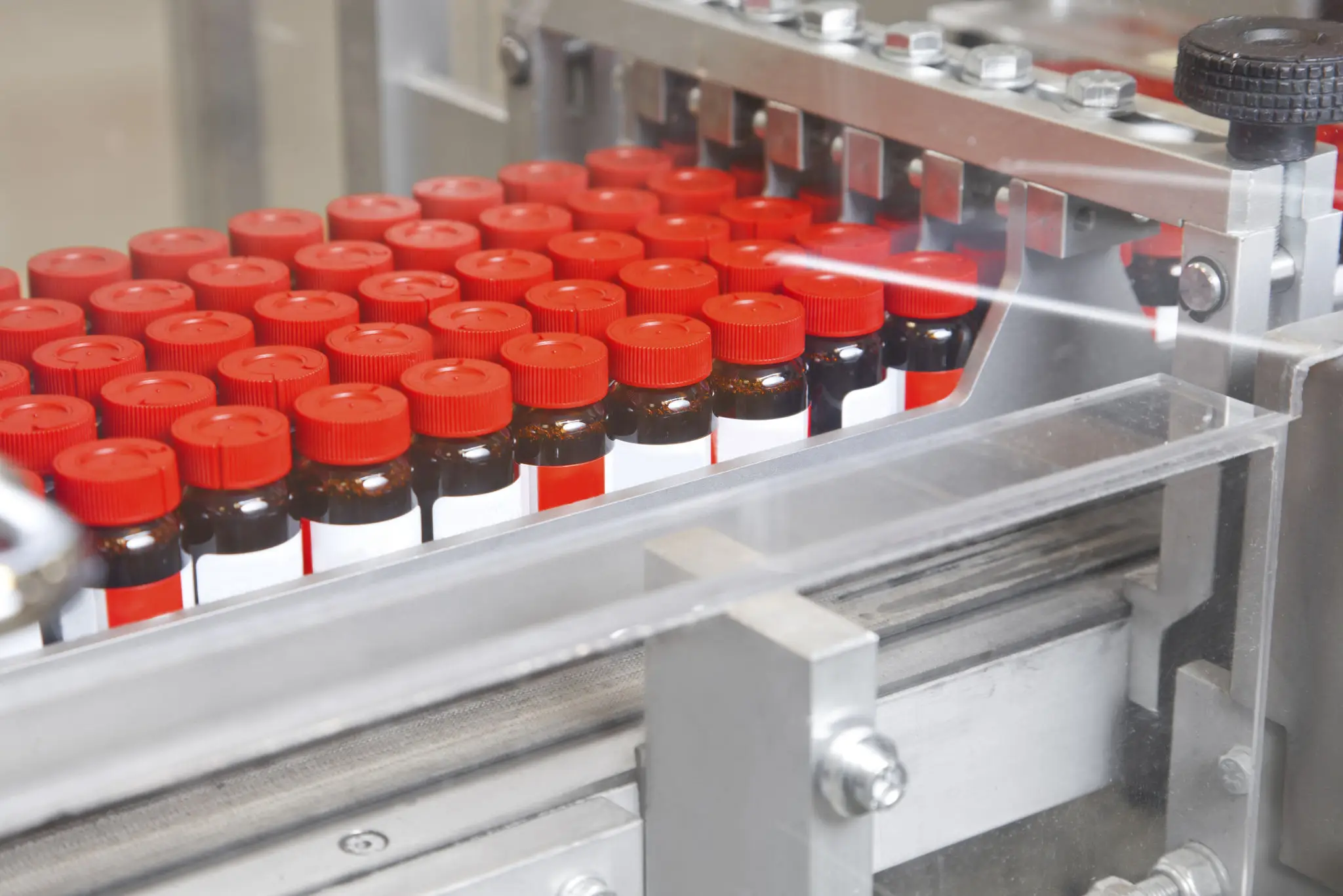 Red-capped vials on assembly line